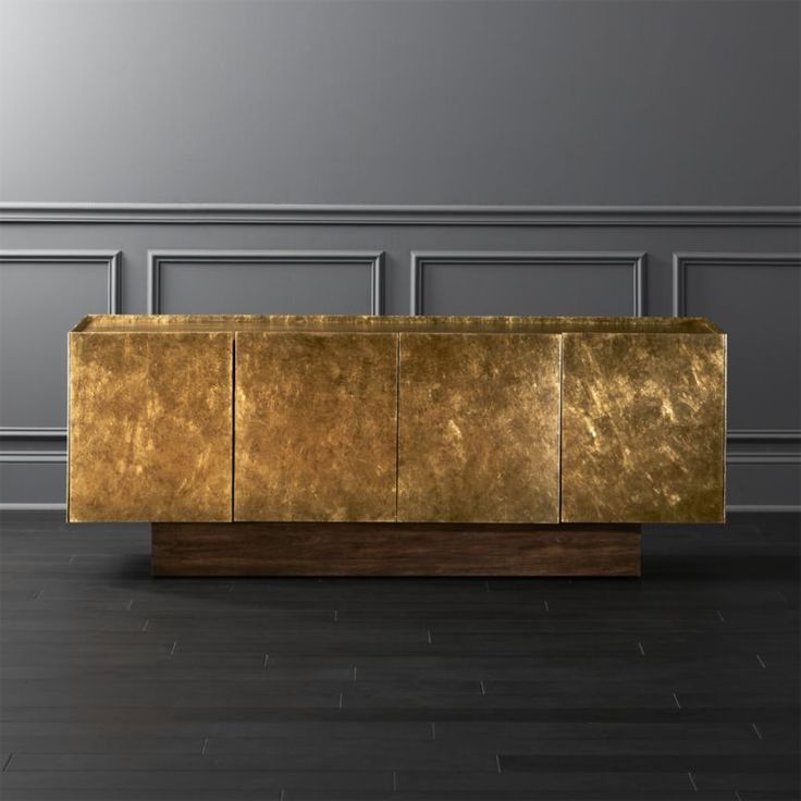 a large golden couch sitting on top of a hard wood floor next to a wall