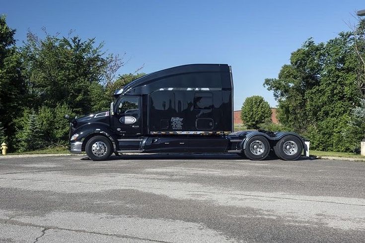 a black semi truck is parked on the street