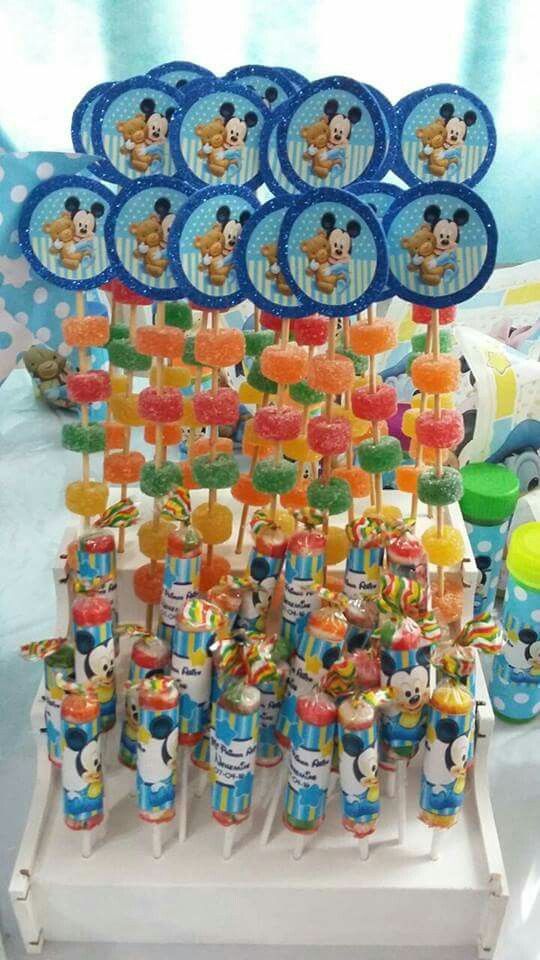 mickey mouse cupcakes and lollipops are on display at a birthday party