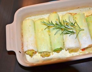 a casserole dish with vegetables wrapped in bread and garnished with rosemary