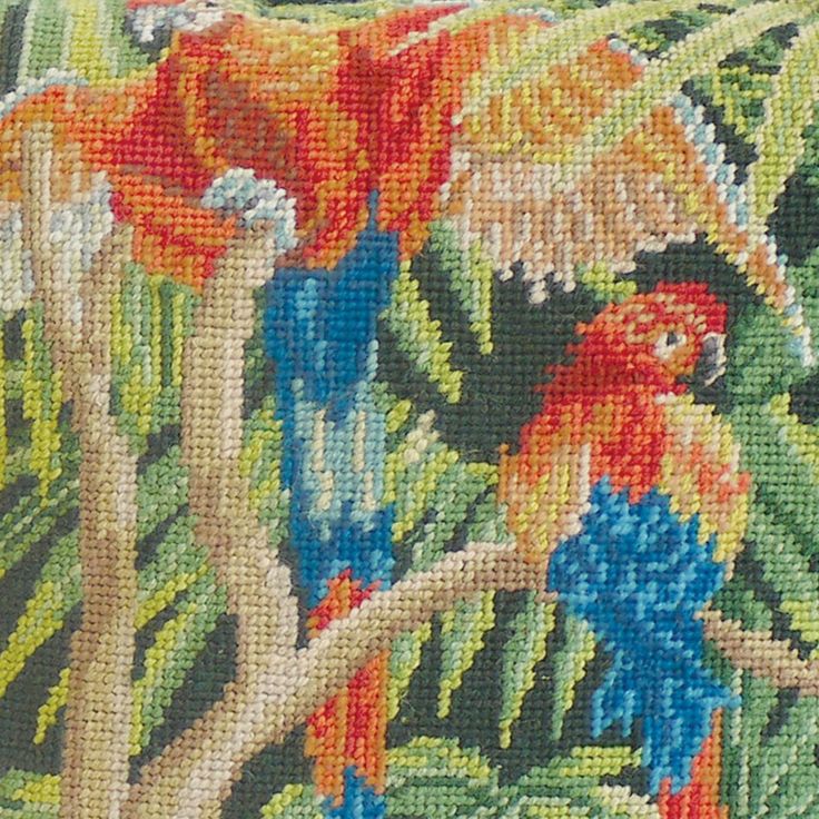 an image of two parrots in the jungle on a pillow cover that looks like it is made out of woven fabric