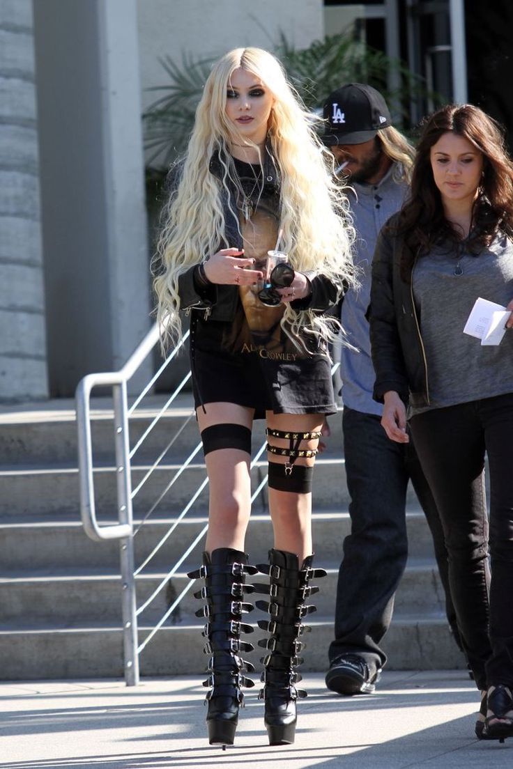 two women walking down the street in thigh high boots