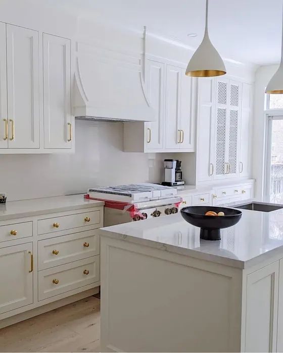 a kitchen with white cabinets and an island