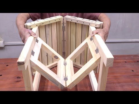 a man is holding two pieces of wood in front of his face and the other side of the chair