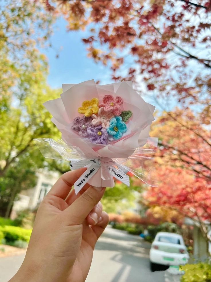 someone is holding up a bouquet of flowers