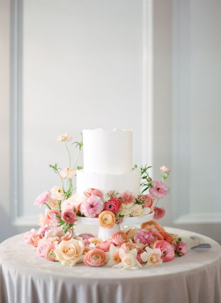 a white wedding cake with pink and orange flowers