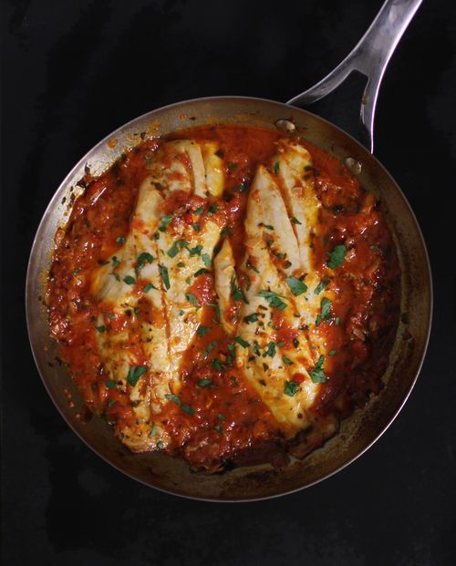 a skillet filled with chicken covered in sauce