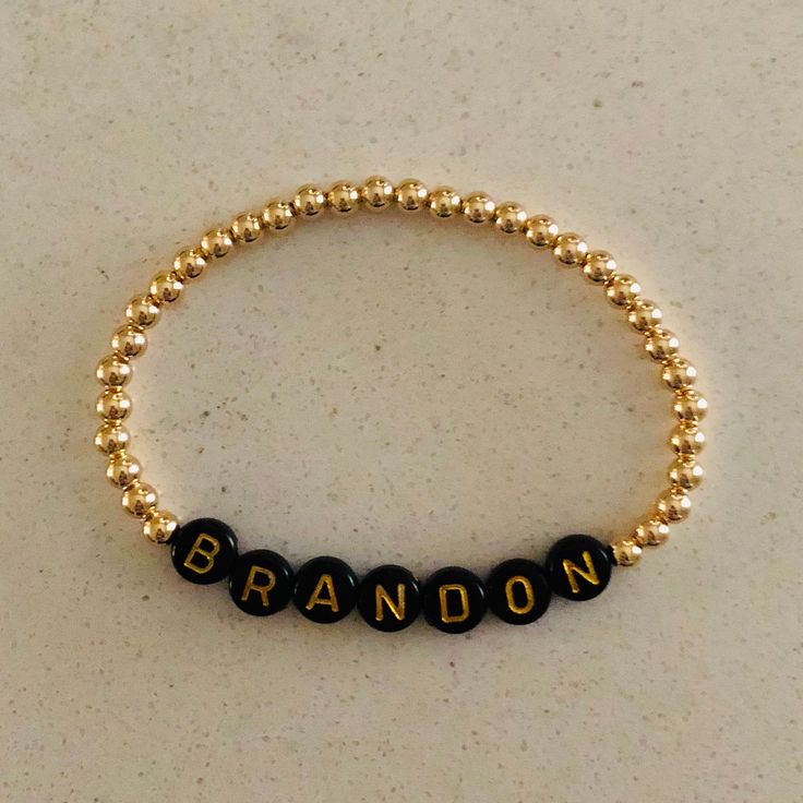 This listing is for 1 custom 14k gold filled 4mm beaded bracelet with black beads with gold letters. Each bracelet can be personalized with a name of your choice along with your desired length. Please leave a note in the comments section when you check out stating what letters you would like. Letter beads will all be placed together with gold beads on either side. These bracelets will not tarnish and look great alone or in a stack! Bracelets come in an organza pouch and make perfect gifts. I wil Personalized Gold Beaded Bracelets, Gold Stretch Bracelet Customizable, Personalized Gold Round Beaded Bracelets, Personalized Gift Gold Beaded Round Bracelets, Personalized Gold Stretch Bracelet, Personalized Gold Beaded Bracelet, Personalized Gold Round Stretch Bracelet, Personalized Gold Name Bracelet With Round Beads, Classic Gold Jewelry With Letter Beads