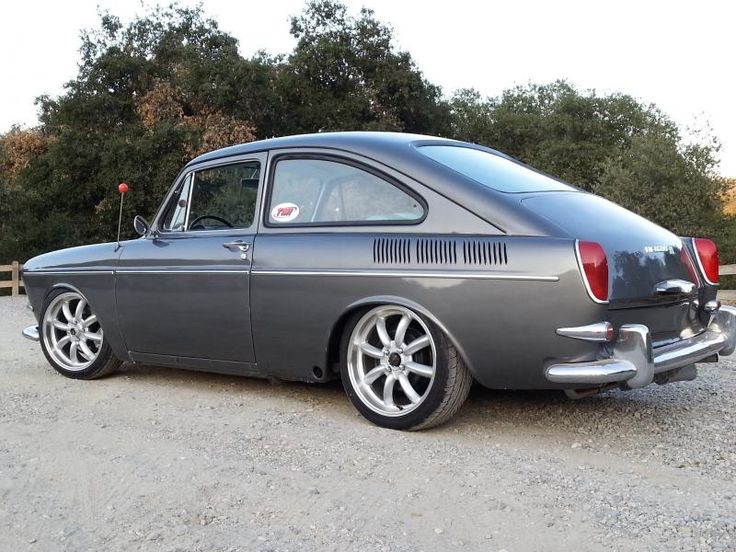 an old car is parked on the gravel