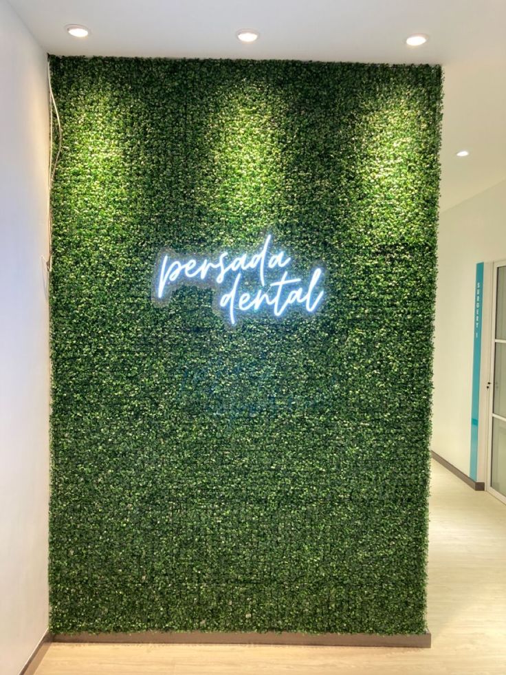 a green wall with the words personal dental written on it in blue neon lights above