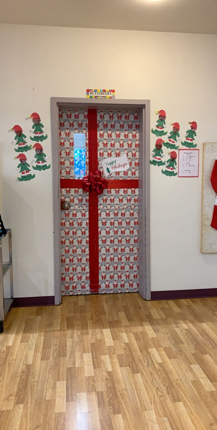 an open door with a red ribbon on it in a room decorated for christmas time