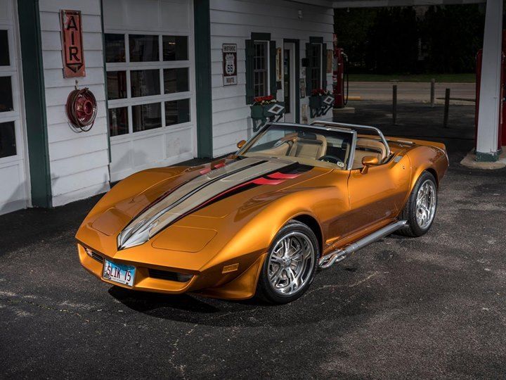 an orange sports car parked in front of a gas station