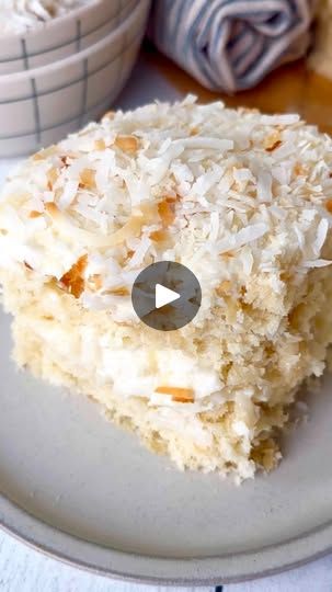 a white plate topped with a piece of cake next to two bowls filled with rice