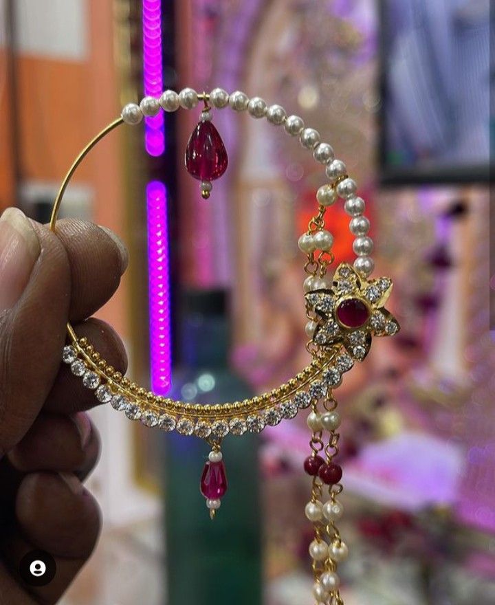 a close up of a person holding a piece of jewelry