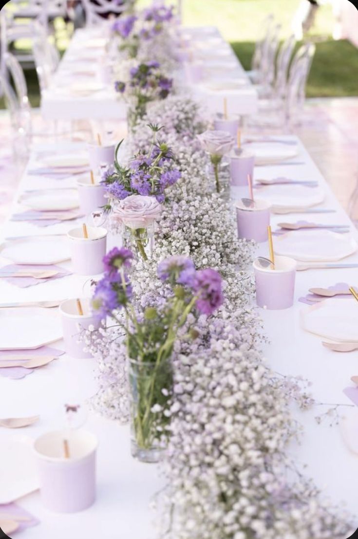 a long table with purple and white flowers on it