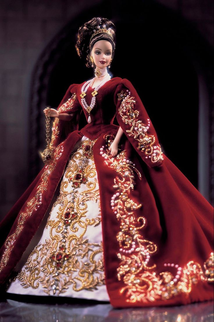 the doll is wearing a red and gold gown