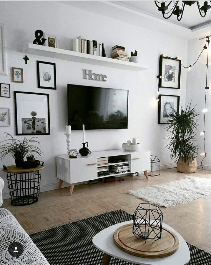 a living room with white furniture and pictures on the wall above it's entertainment center