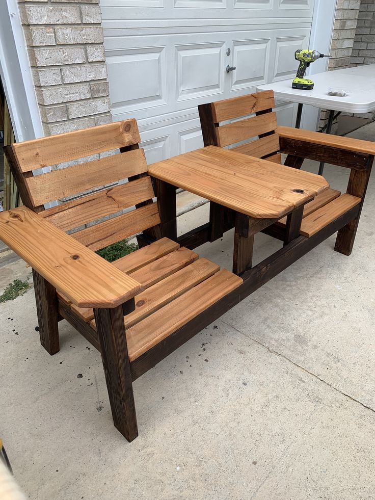 two wooden benches sitting next to each other in front of a garage door