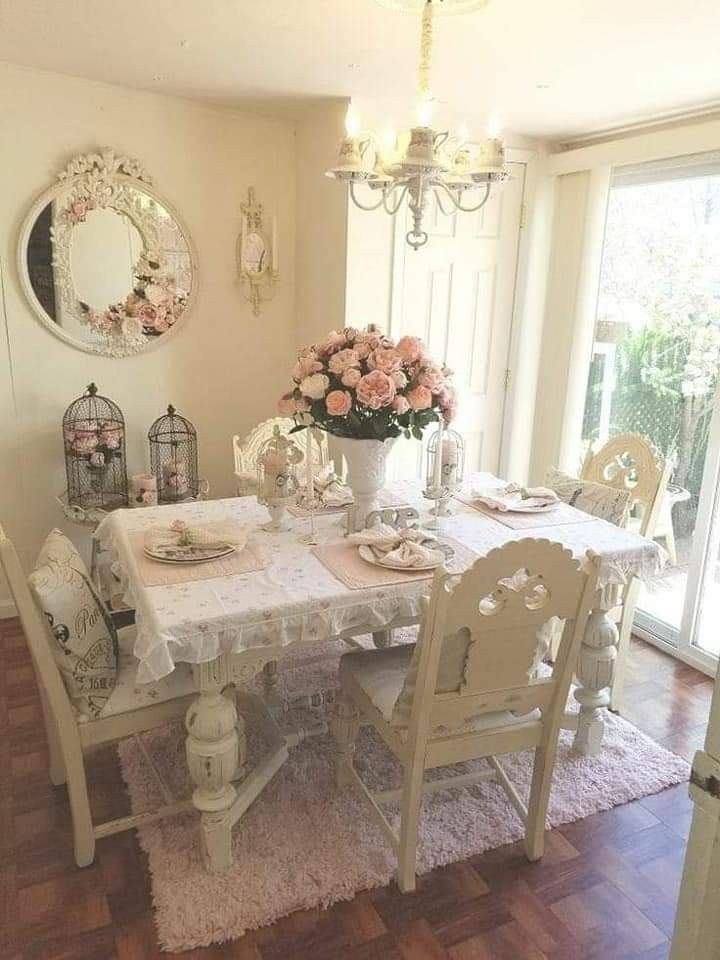 a dining room table and chairs in front of a large window with flowers on it