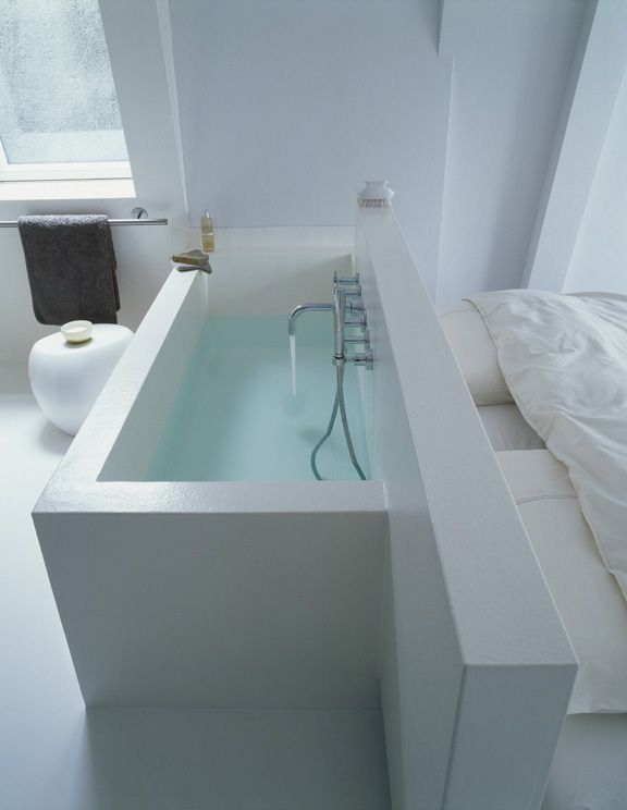 a bathtub in the middle of a white bathroom