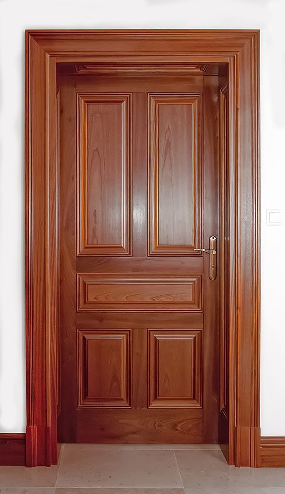 an empty room with a wooden door and tile floor