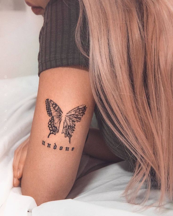 a woman with a butterfly tattoo on her left arm and the word endome written in black ink