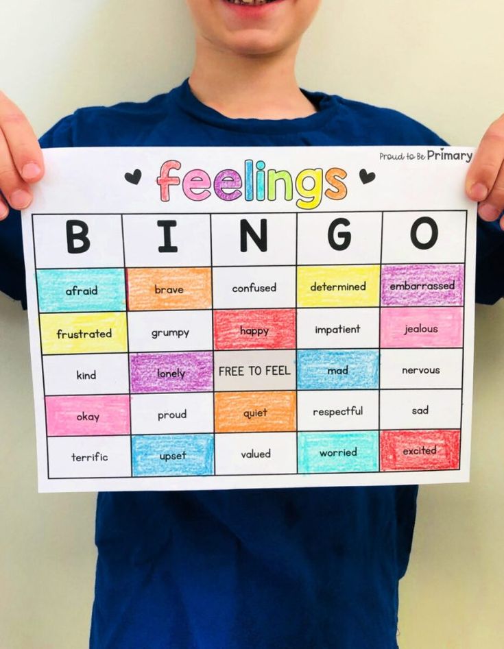 a young boy holding up a sign that says feelings bingo