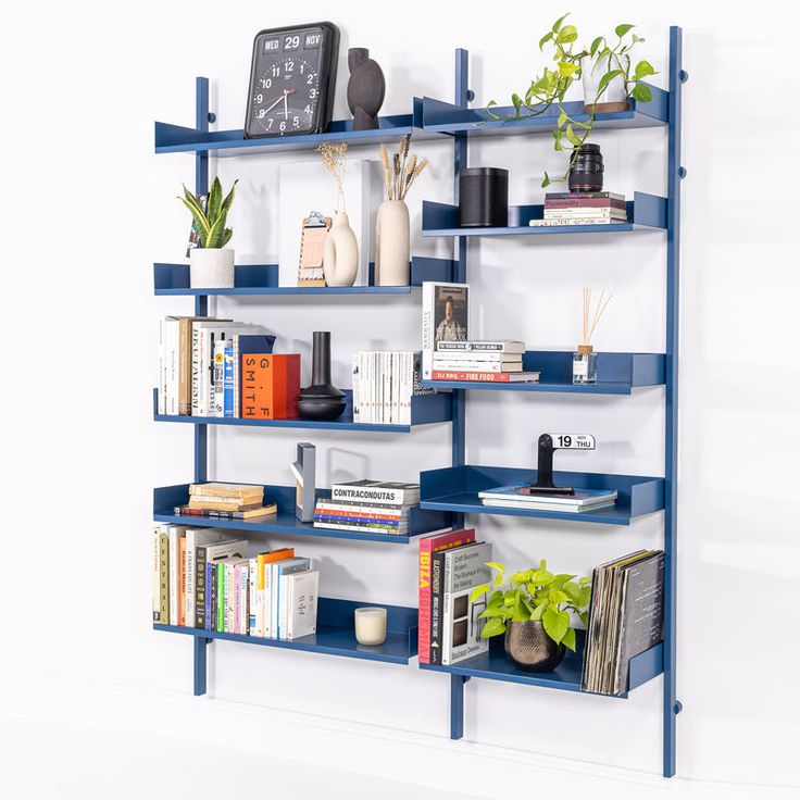 a blue shelf with books and plants on it