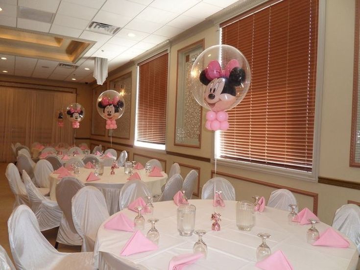 a room filled with lots of tables covered in white linens and pink napkins