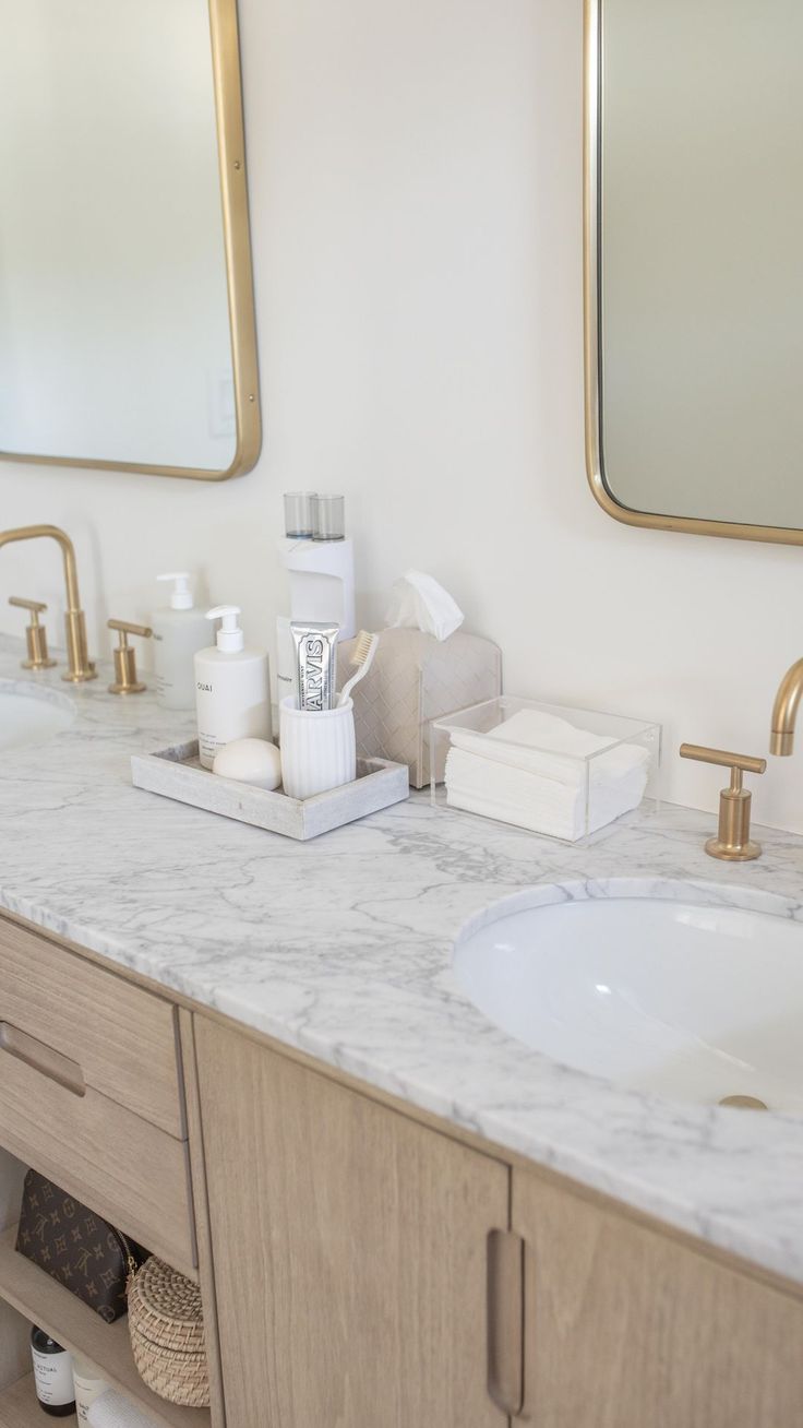 a bathroom vanity with two sinks and mirrors