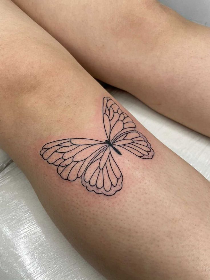 a small butterfly tattoo on the right arm and leg, it looks like an insect