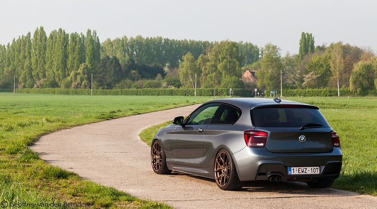 a silver car parked on the side of a road next to a lush green field