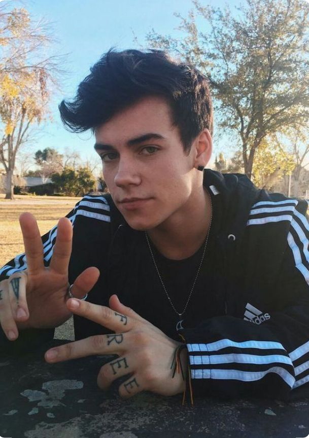 a young man making the peace sign with his hands and fingers in front of him