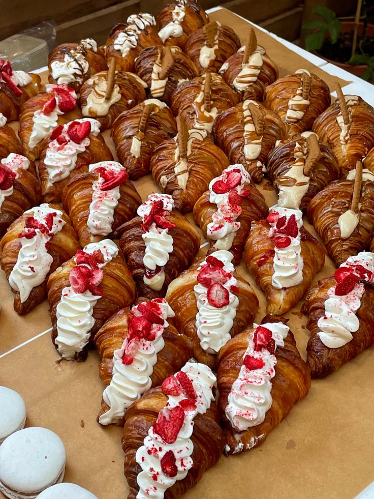 there are many croissants with white frosting and red decorations on them