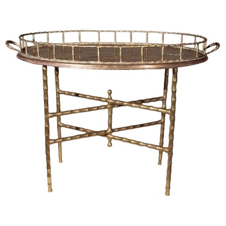 a round tray with metal handles and bamboo trimmings on the bottom, sitting on a stand