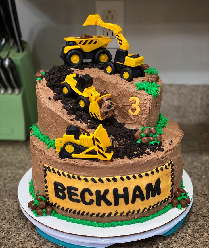 a birthday cake decorated with construction vehicles and dirt