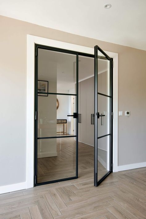 an empty room with glass doors and wood flooring on either side of the door