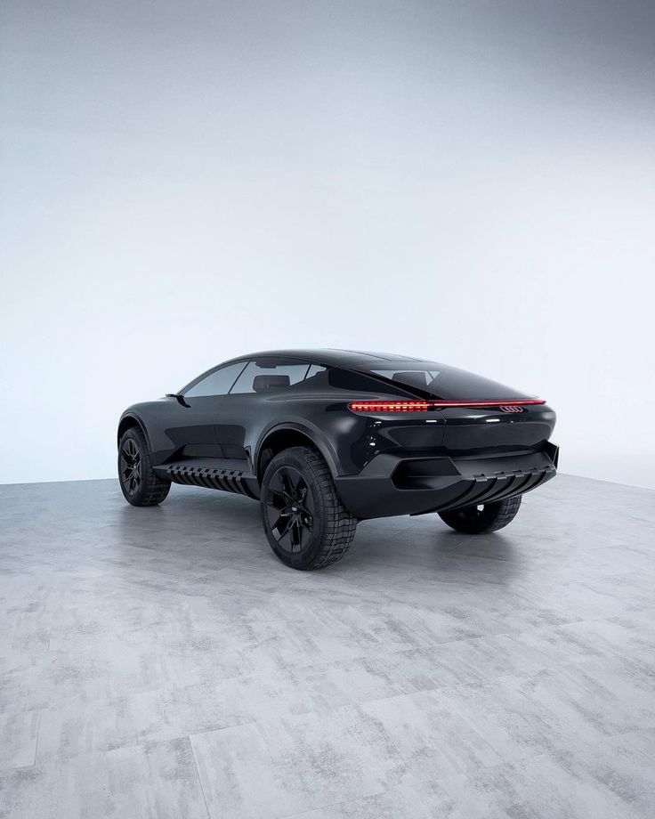 the rear end of a black sports car in a white room with concrete flooring