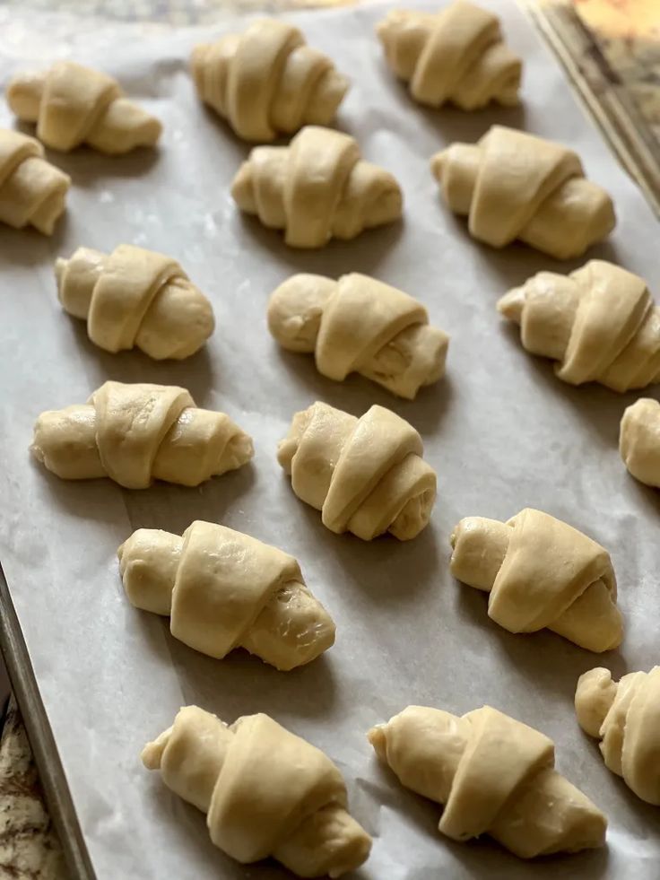 doughnuts are lined up on a baking sheet and ready to go into the oven