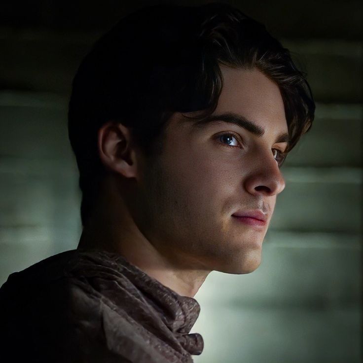 a close up of a person wearing a brown shirt and looking off into the distance