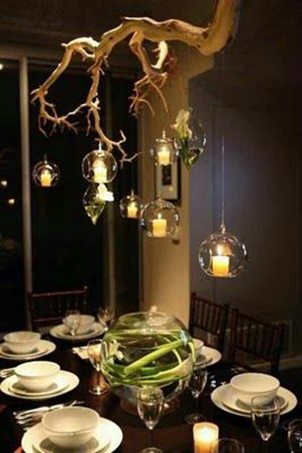 a dining room table is set with plates, candles and glass vases for centerpieces