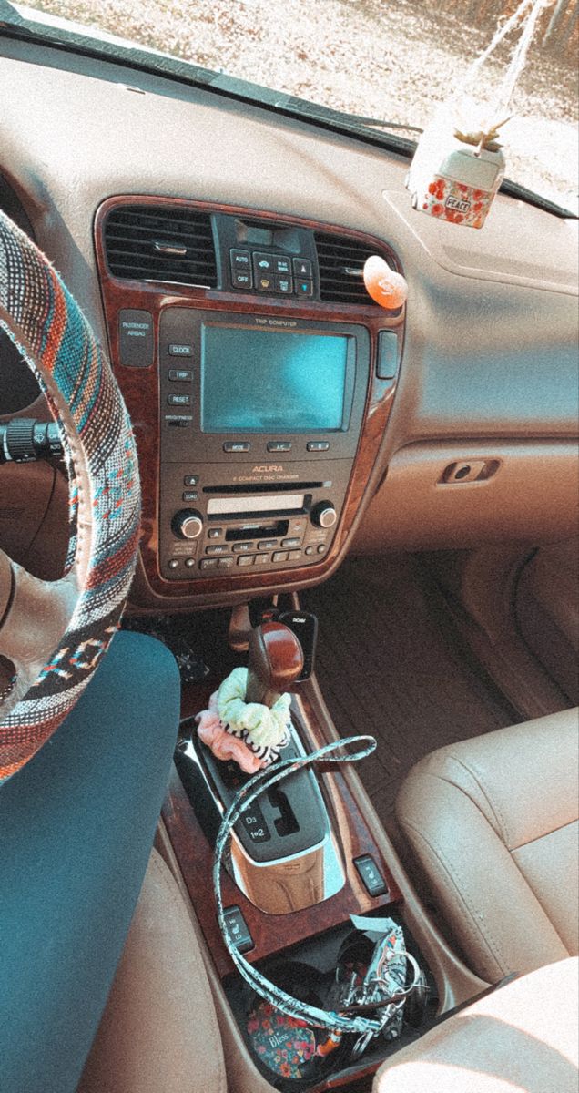 the interior of a car with steering wheel and various items on the dash board in it