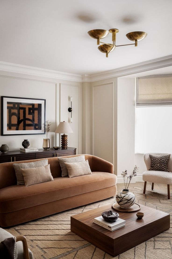 a living room filled with furniture and a painting on the wall above it's windows