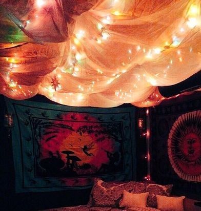 a bed with lights on the headboard and canopy over it in a room filled with curtains