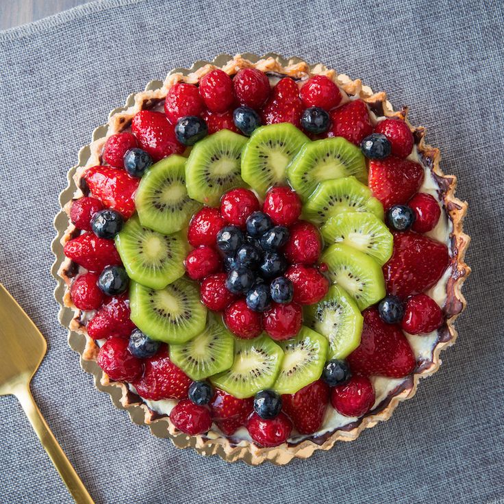 a pie with kiwis, strawberries and blueberries on top