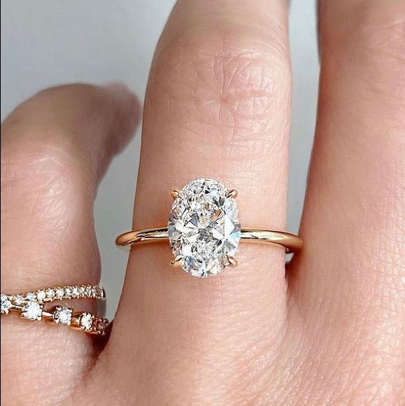 a woman's hand with two gold rings and a diamond ring on her finger