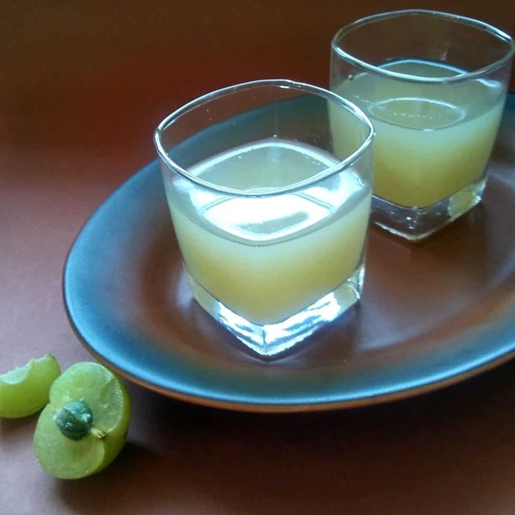 two glasses filled with liquid sitting on top of a blue plate