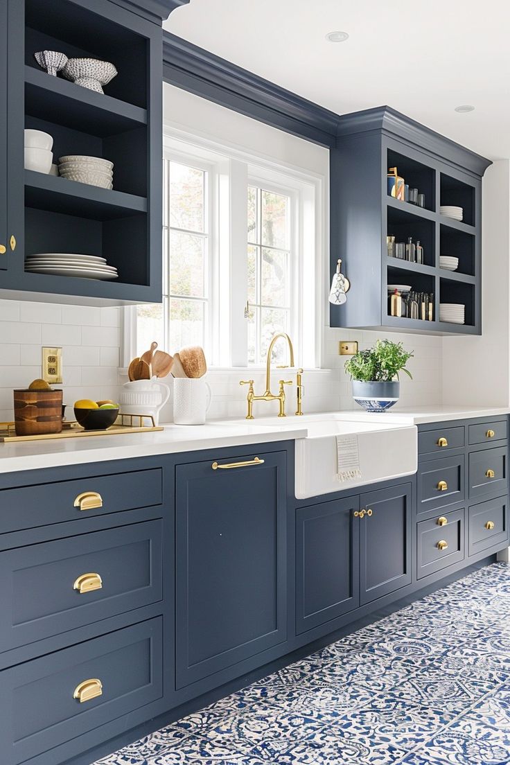 a kitchen with blue cabinets and gold pulls on the handles, white counter tops, and an area rug