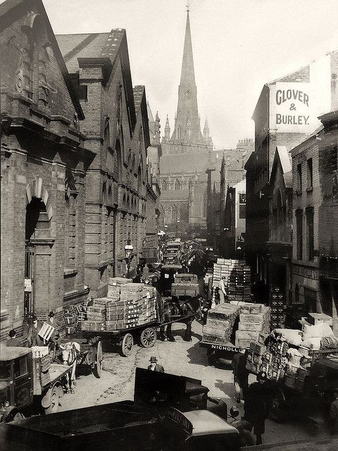 an old black and white photo of people on the street