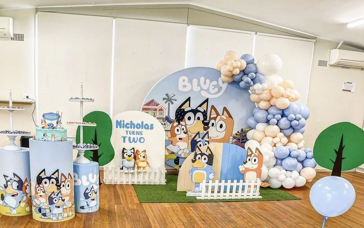 balloons and decorations are on the floor in front of a backdrop for a children's birthday party